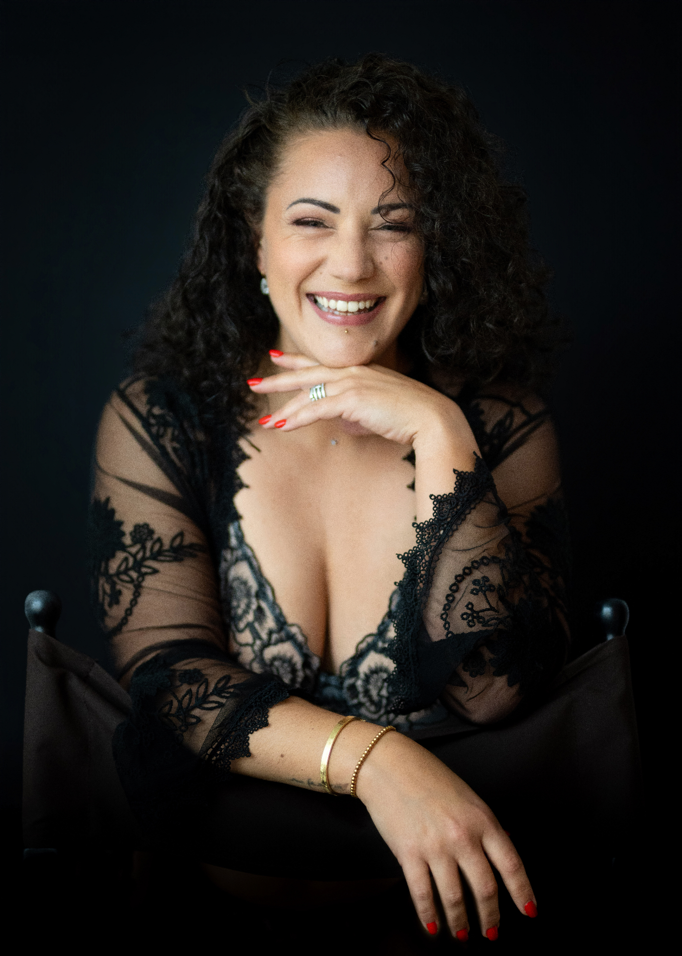 Portrait boudoir authentique d'une femme souriante en lingerie de dentelle